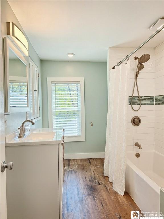 55 Washington Ave, Pomfret, NY 14063 - bathroom with healthy amount of natural light, wood finished floors, vanity, and shower / bath combo