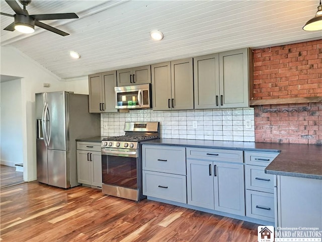 55 Washington Ave, Pomfret, NY 14063 - kitchen featuring stainless steel appliances, dark countertops, a ceiling fan, decorative backsplash, and wood finished floors