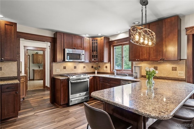 60 Kettle Run, Elma, NY 14052 - kitchen with appliances with stainless steel finishes, a breakfast bar, a peninsula, glass insert cabinets, and light stone counters