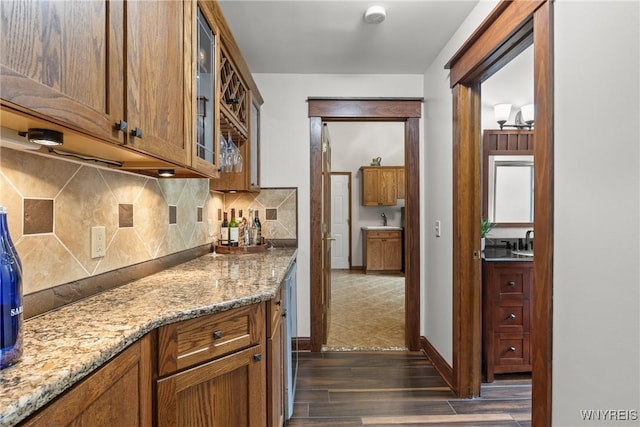60 Kettle Run, Elma, NY 14052 - kitchen featuring dark wood-type flooring, tasteful backsplash, glass insert cabinets, brown cabinets, and light stone countertops