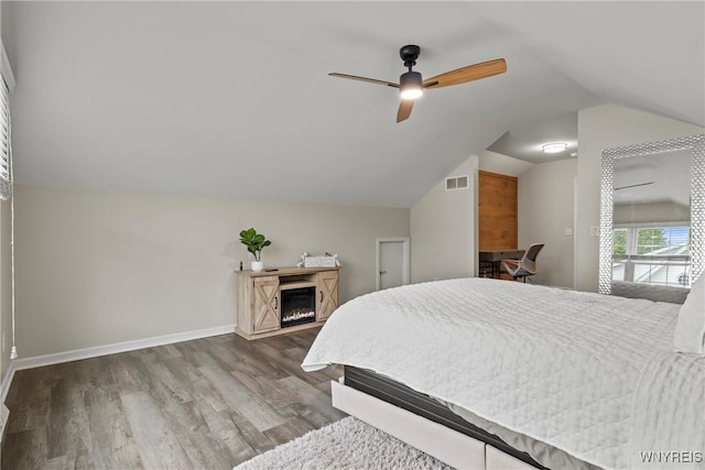 60 Kettle Run, Elma, NY 14052 - bedroom featuring vaulted ceiling, wood finished floors, a lit fireplace, and a ceiling fan