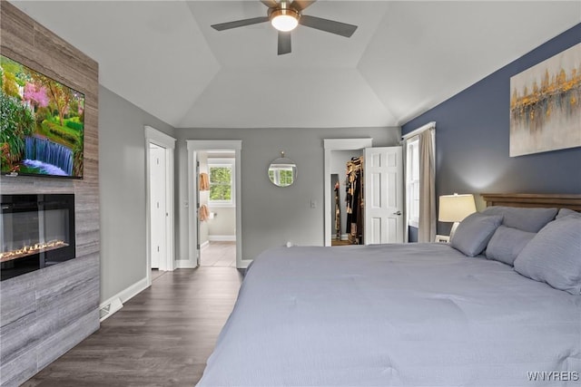 60 Kettle Run, Elma, NY 14052 - bedroom featuring ensuite bath, a walk in closet, a fireplace, wood finished floors, and vaulted ceiling