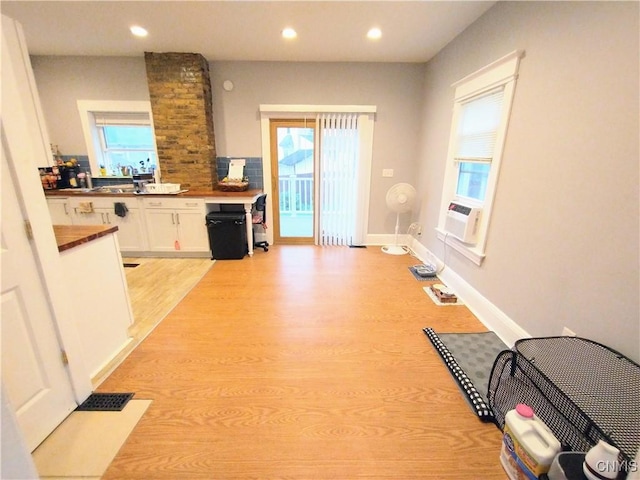 kitchen featuring white cabinetry, light wood-style floors, recessed lighting, cooling unit, and baseboards