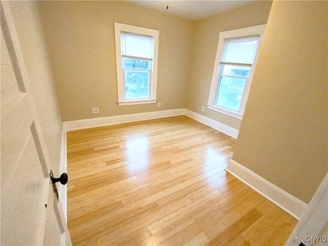 empty room featuring wood finished floors and baseboards