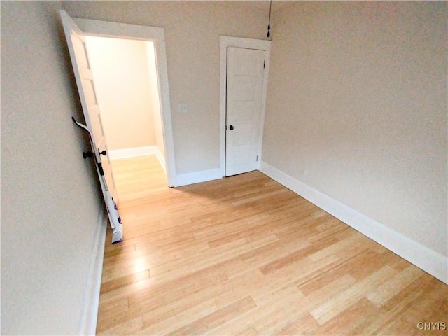 spare room featuring light wood-type flooring and baseboards
