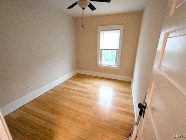 spare room featuring light wood-style floors, ceiling fan, and baseboards