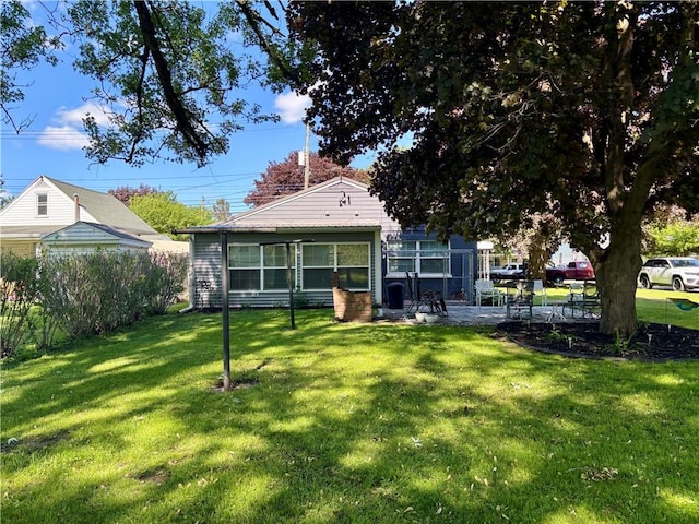 99 N Main St, Mount Morris, NY 14510 - rear view of property featuring a yard and a patio area