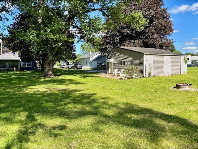 99 N Main St, Mount Morris, NY 14510 - view of grassy yard featuring an outdoor fire pit and an outdoor structure