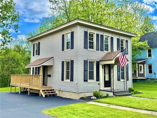 view of front of property featuring a front lawn and a wooden deck