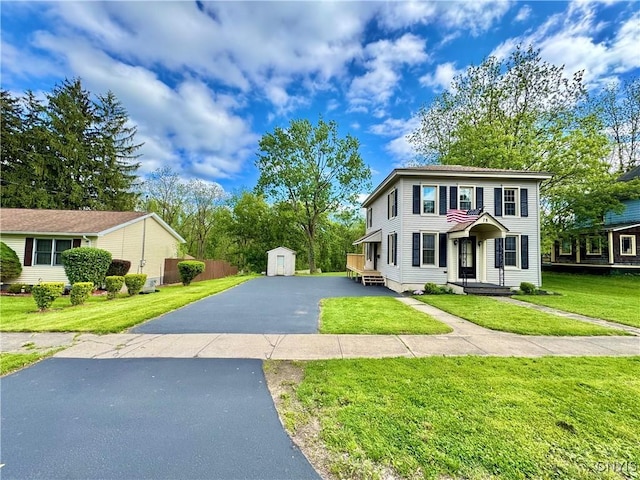 colonial home featuring driveway and a front lawn