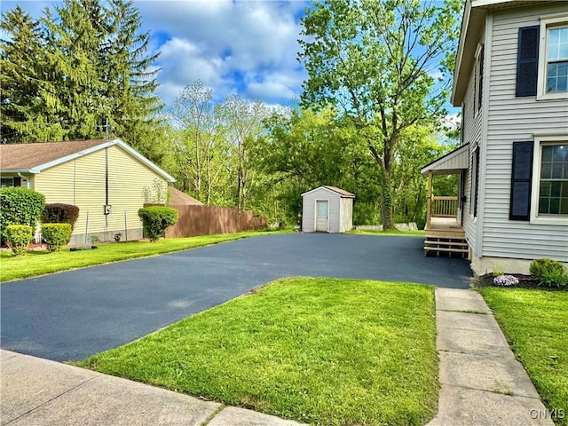 view of yard featuring asphalt driveway