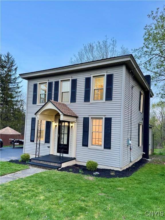 colonial home featuring a front lawn