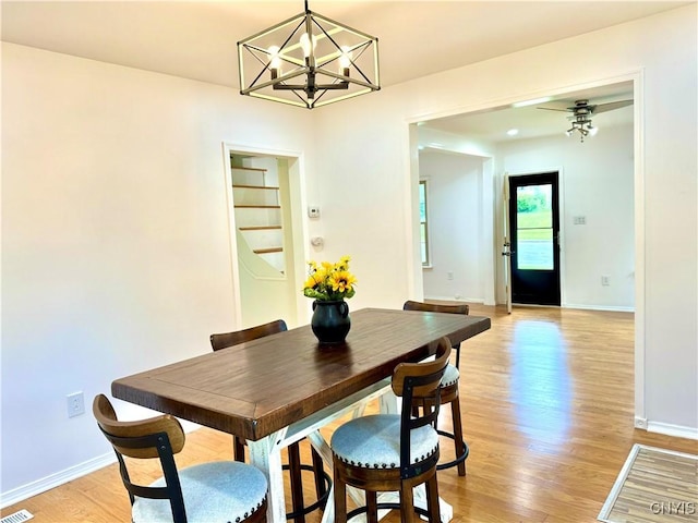 dining room with light wood-style flooring, baseboards, and a chandelier