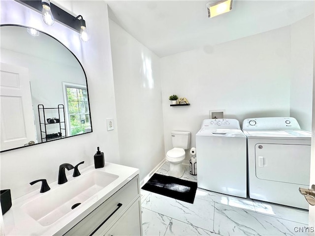 bathroom with independent washer and dryer, marble finish floors, toilet, and vanity