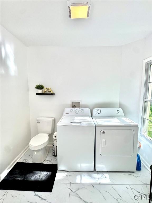 washroom with independent washer and dryer, light marble finish flooring, and baseboards