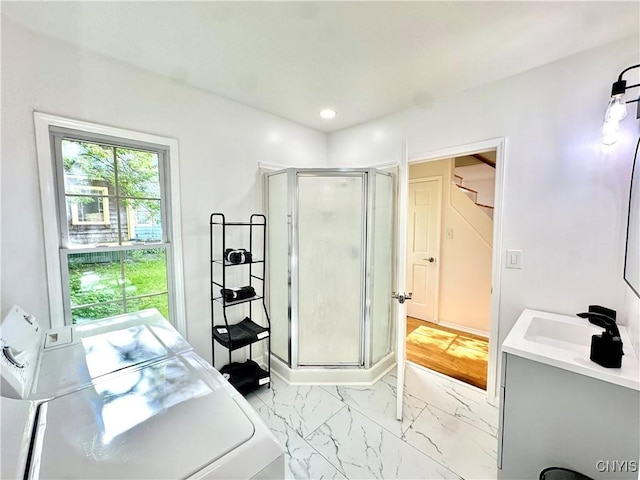 bathroom featuring a shower stall, washer / dryer, marble look tiles, vanity, and recessed lighting