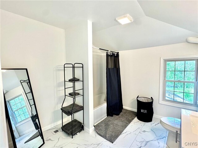 full bathroom with marble look tile flooring, shower / bath combination with curtain, toilet, baseboards, and lofted ceiling