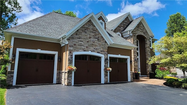 31 Putney Pl, Greece, NY 14468 - view of front of home featuring stone siding, a garage, stucco siding, and driveway