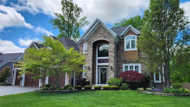 31 Putney Pl, Greece, NY 14468 - view of front facade featuring stone siding, a front lawn, driveway, and an attached garage