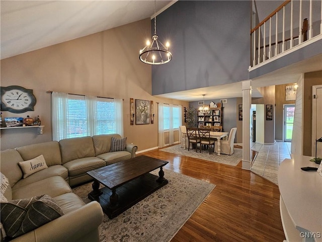 108 Sunflower Cir, Frankfort, NY 13340 - living room featuring a chandelier, high vaulted ceiling, wood finished floors, baseboards, and ornate columns