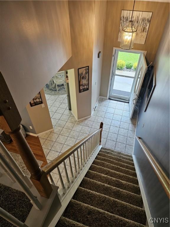 108 Sunflower Cir, Frankfort, NY 13340 - staircase featuring tile patterned floors, baseboards, and a towering ceiling
