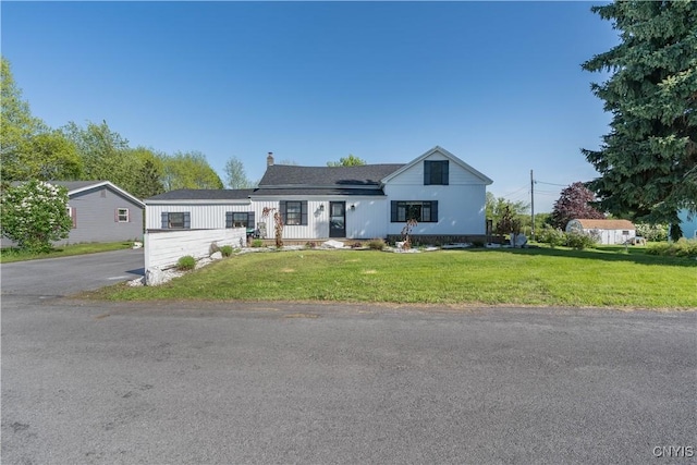 20304 Burton Rd, Hounsfield, NY 13685 - view of front of house featuring a front lawn, a chimney, and asphalt driveway