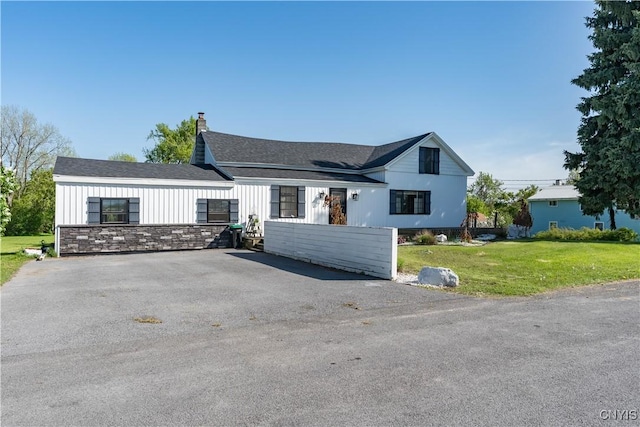 20304 Burton Rd, Hounsfield, NY 13685 - modern farmhouse style home with driveway, a chimney, a front yard, and board and batten siding