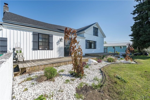 20304 Burton Rd, Hounsfield, NY 13685 - view of front of home featuring a deck, a front lawn, board and batten siding, and a chimney