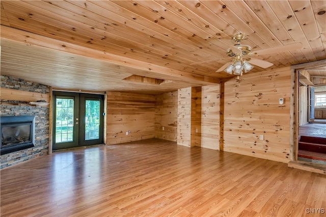 20304 Burton Rd, Hounsfield, NY 13685 - unfurnished living room with wood ceiling, wood finished floors, ceiling fan, a fireplace, and wooden walls