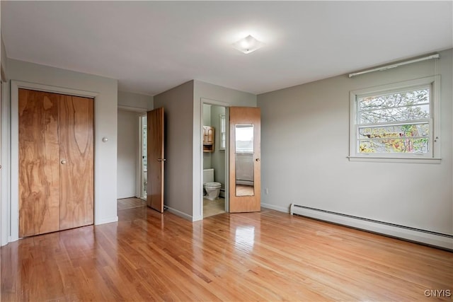 18 Court Knolle, New Hartford, NY 13413 - unfurnished bedroom with baseboard heating, wood finished floors, multiple windows, and baseboards