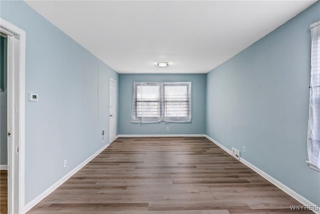 spare room featuring wood finished floors and baseboards