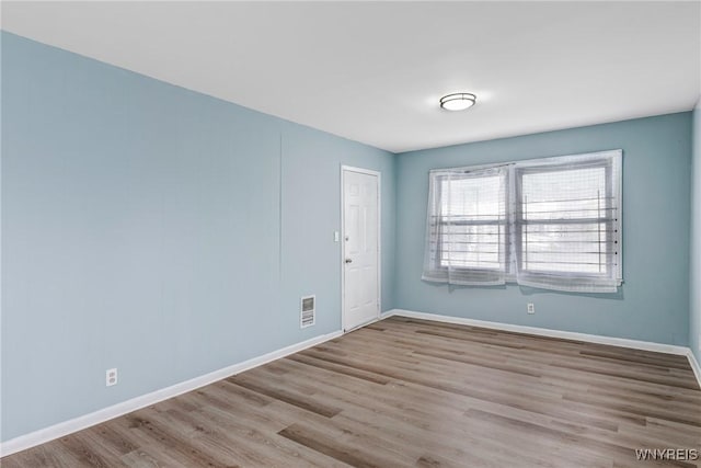 spare room featuring wood finished floors and baseboards