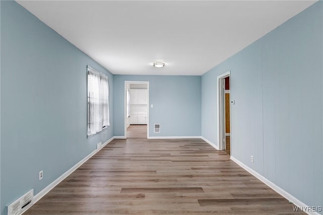 unfurnished room with baseboards and wood finished floors