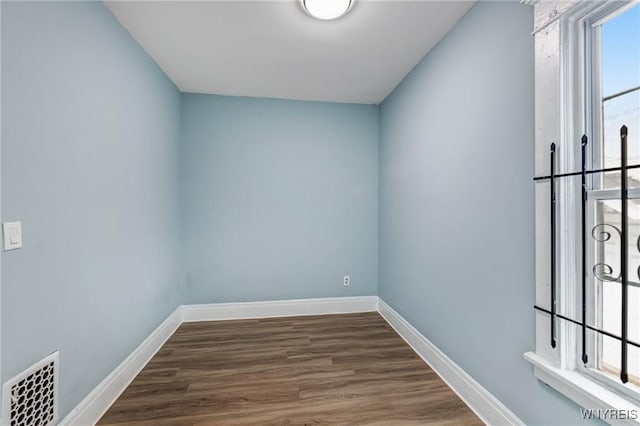 unfurnished room with wood finished floors and baseboards
