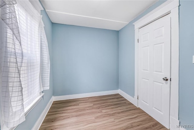 spare room featuring wood finished floors and baseboards