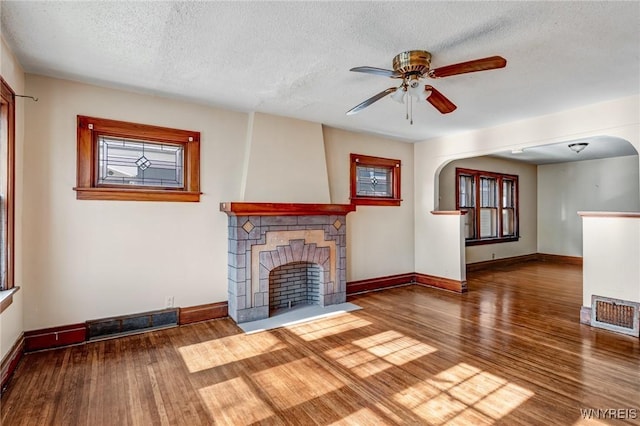 27 E End Ave, Cheektowaga, NY 14225 - unfurnished living room with wood finished floors, ceiling fan, baseboards, a textured ceiling, and a fireplace