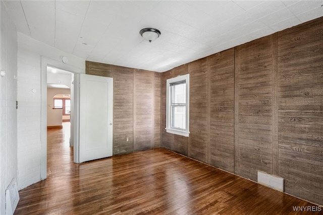 27 E End Ave, Cheektowaga, NY 14225 - unfurnished bedroom with arched walkways, wood finished floors, and wooden walls