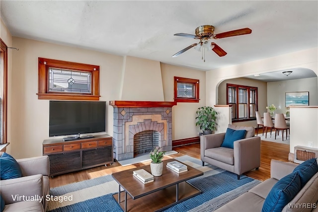 27 E End Ave, Cheektowaga, NY 14225 - living area with a ceiling fan, wood finished floors, arched walkways, a fireplace, and baseboards