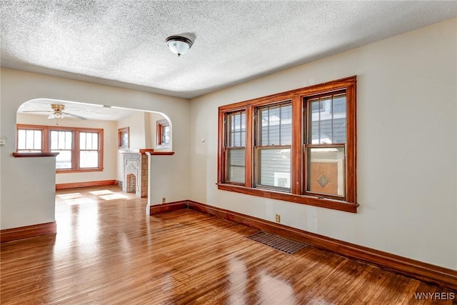 27 E End Ave, Cheektowaga, NY 14225 - unfurnished room with baseboards, wood finished floors, arched walkways, a textured ceiling, and a ceiling fan