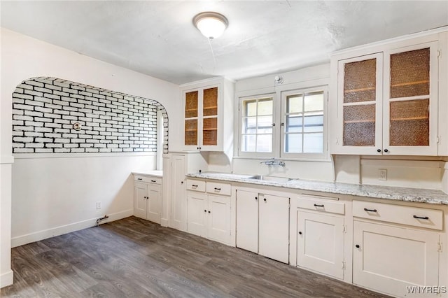 27 E End Ave, Cheektowaga, NY 14225 - kitchen with a sink, dark wood finished floors, glass insert cabinets, light stone countertops, and baseboards