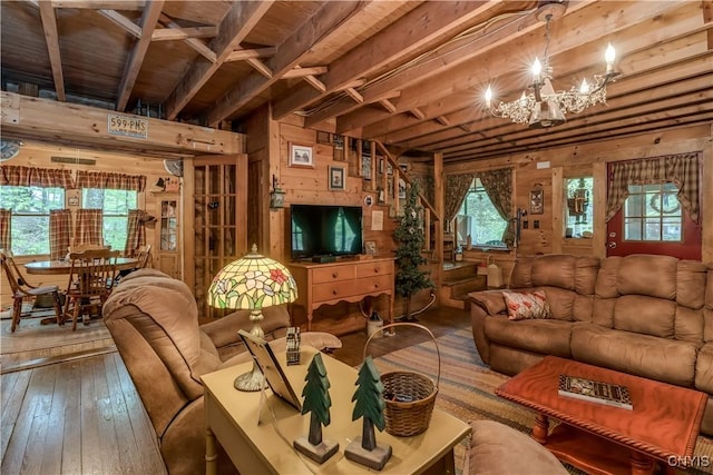 living room featuring wooden walls, a chandelier, healthy amount of natural light, hardwood / wood-style flooring, and wood ceiling