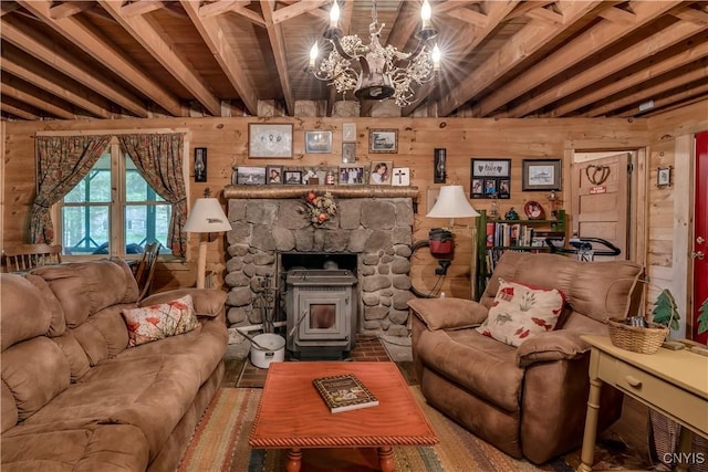 living room with beamed ceiling, a chandelier, wood walls, and a wood stove