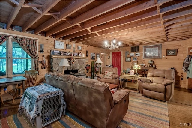 living area with wood finished floors, a chandelier, wooden walls, and beamed ceiling