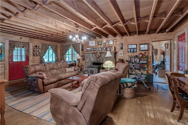 living area with hardwood / wood-style floors, wooden walls, and a chandelier