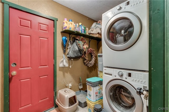 laundry area with estacked washer and dryer and a textured ceiling