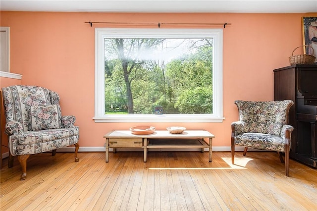 sitting room with plenty of natural light, light wood-type flooring, and baseboards