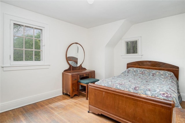 bedroom with light wood-type flooring and baseboards