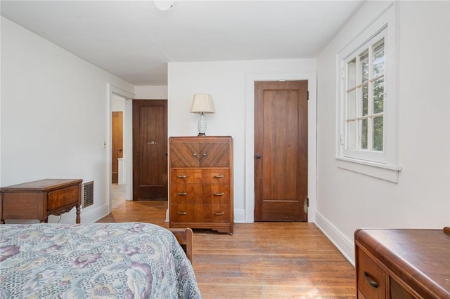 bedroom with light wood-style flooring and baseboards
