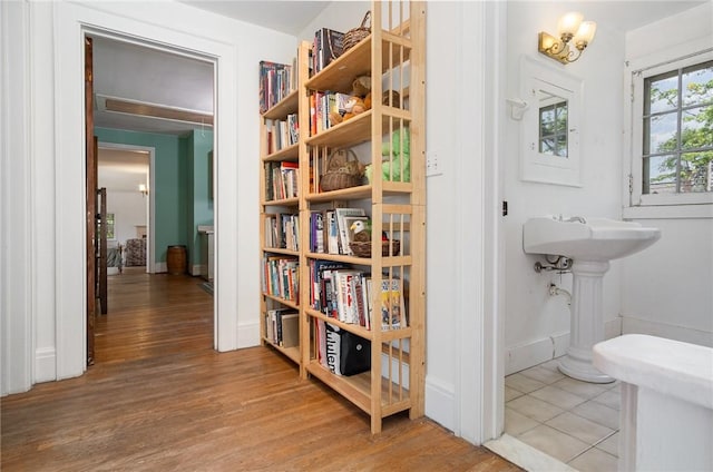 corridor featuring wood finished floors and baseboards