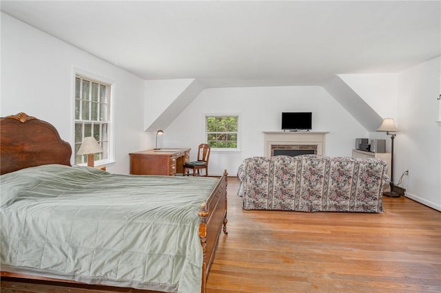 bedroom featuring light wood finished floors and a fireplace